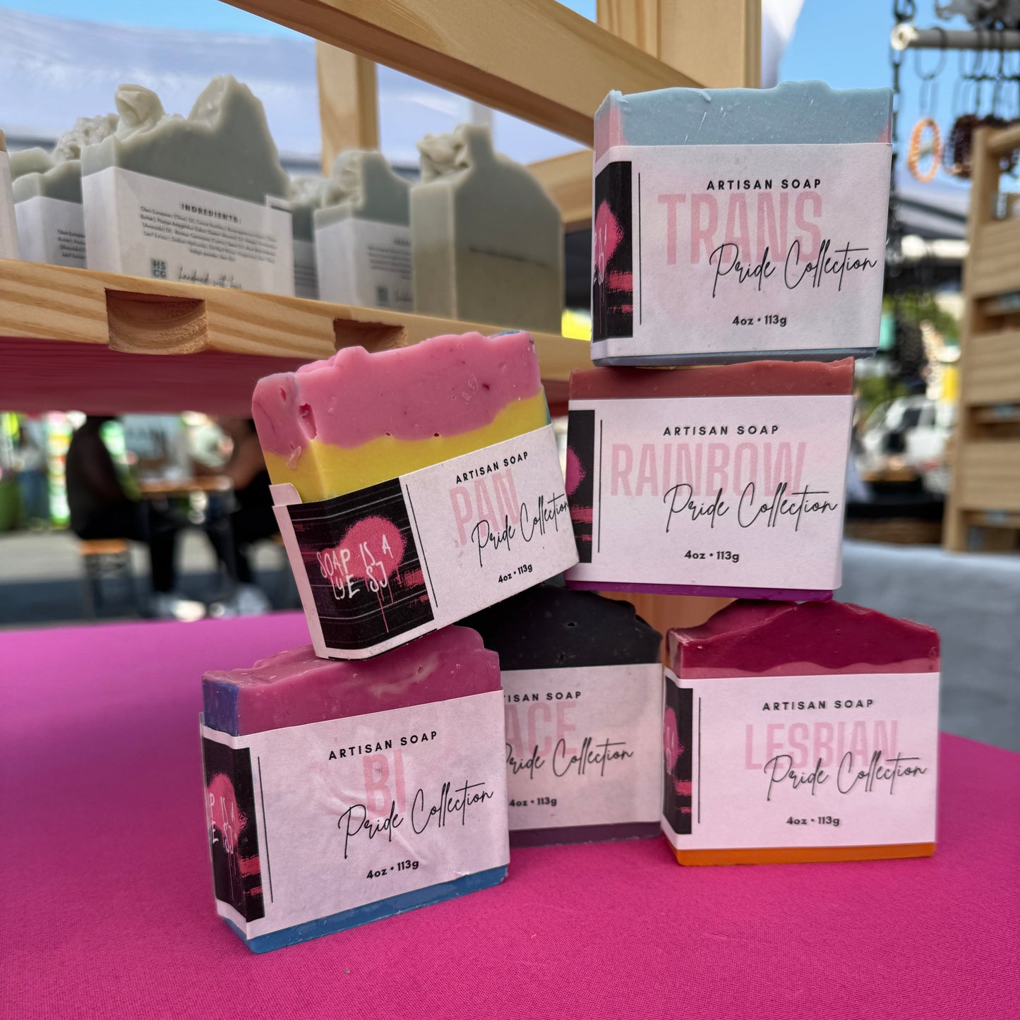 Packaged soap products with visible branding on a pink surface