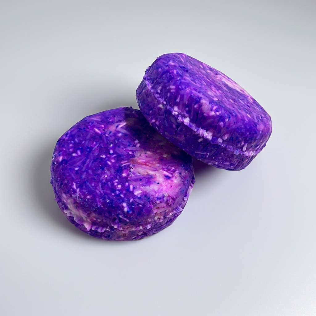shampoo bar sitting on top of another shampoo bar showcasing the purple and pink colors on a white background