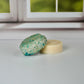 Detox shampoo bar and conditioner bars sitting on a white table with a window in the background