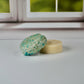 Detox shampoo bar and conditioner bars sitting on a white table with a window in the background