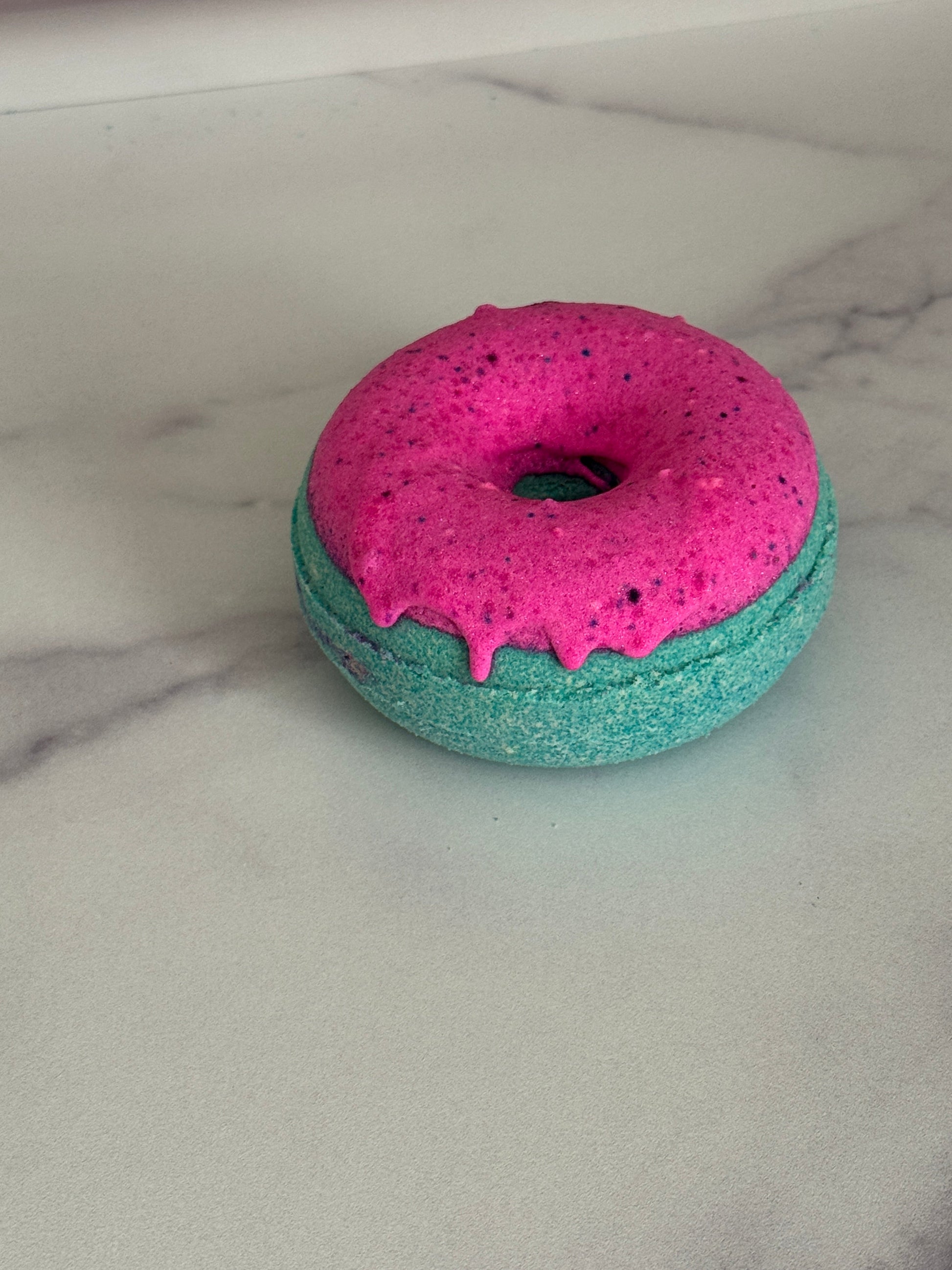 Donut bath bomb that is green with pink frosting