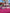 Soap bars featuring: Lesbian Pride, Trans Pride, Pan Pride, Rainbow Pride, Bi Pride, Ace pride, all stacked together on a pink surface with a blurred outdoor background.